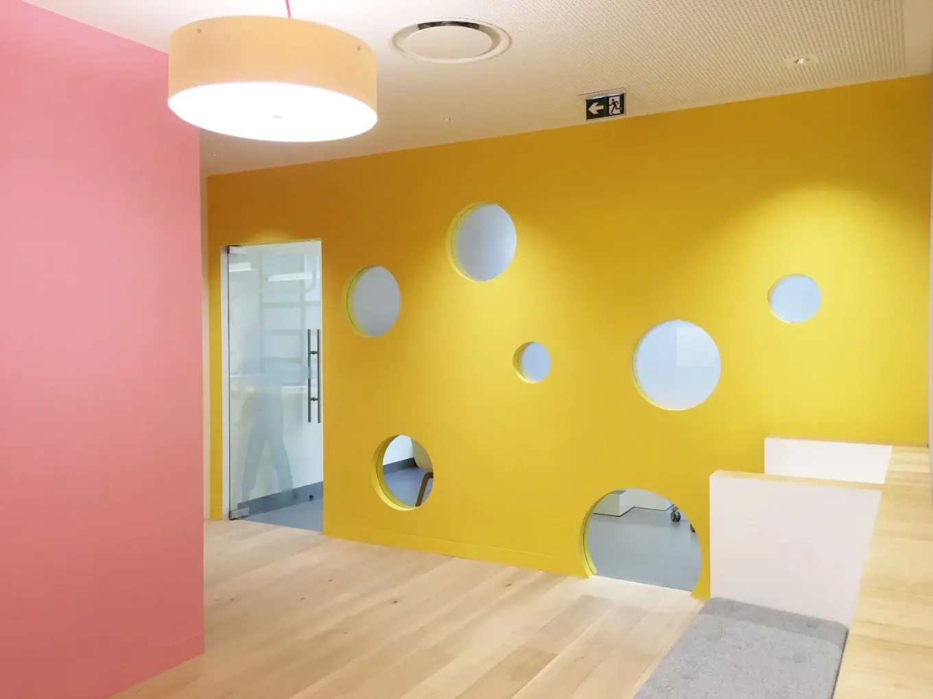 Espace d'accueil enfants du Cabinet Dentaire 10 Prague — mur jaune et hublots colorés